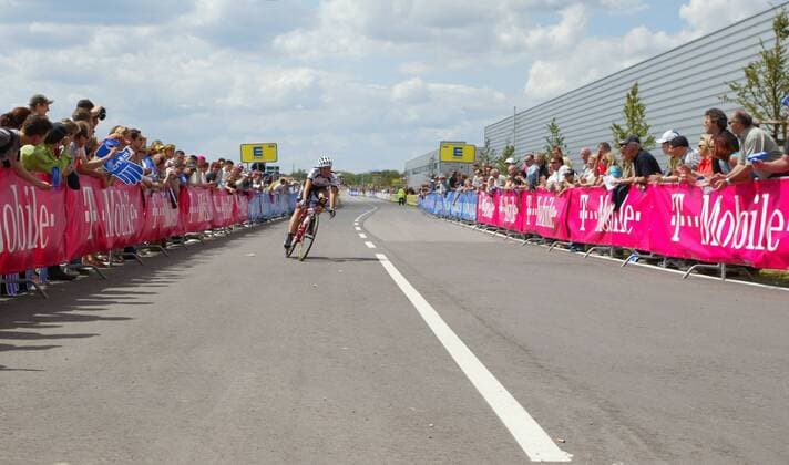 Radsportler steuert eine Kurve an; auf den Werbebanden dominiert t-mobile Radsport Herren Deutschlandtour 2004, Deutschlandrundfahrt, Rundfahrt, Straßenradsport, Straße, Rad, Zeitfahren Totale 1. Etappe: Einzelzeitfahren Karlsruhe Karlsruhe