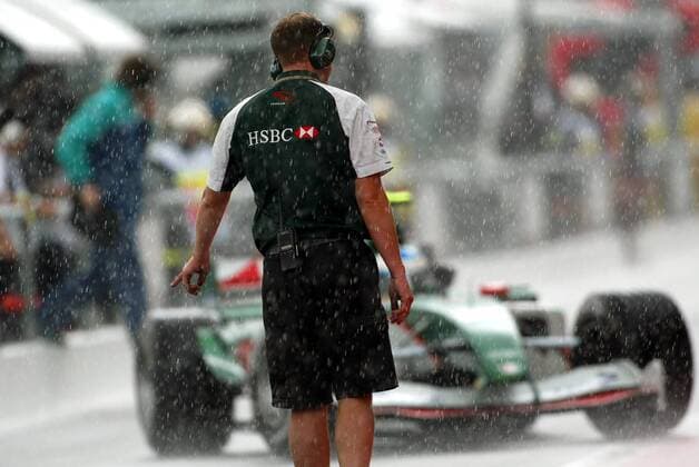 Ein Crewmitglied von Jaguar-Cosworth ordert bei dem starken Regen einen der beiden Piloten an die Box Motorsport Grand Prix Herren Großer Preis von Frankreich 2004, Formel 1 Weltmeisterschaft, F1, F, GP, WM, Freies Training Einzelbild Circuit de Nevers Magny-Cours