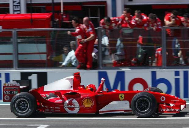 Michael Schumacher (Deutschland Ferrari) fährt dicht an der Boxenmauer vorbei und feiert seinen Sieg Motorsport Grand Prix Herren Großer Preis von Frankreich 2004, Formel 1 Weltmeisterschaft, F1, F, GP, WM Totale Magny-Cours Freude,