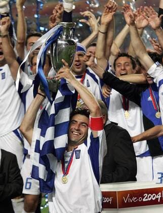 Kapitän Theodoros Zagorakis (Griechenland) stemmt den EM-Pokal im Kreise seiner Teamkollegen Fußball EM Herren Europameisterschaft, Euro 2004, Länderspiel, Nationalmannschaft, Nationalteam, Finale, Endspiel Gruppe Lissabon Glück, Begeisterung, Freude,