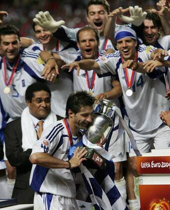 Kapitän Theodoros Zagorakis (Griechenland) stemmt den EM-Pokal im Kreise seiner Teamkollegen, Fußballlegende Eusebio (links dahinter, Portugal) mit fairem Applaus Fußball EM Herren Europameisterschaft, Euro 2004, Länderspiel, Nationalmannschaft, Nationalteam, Finale, Endspiel Gruppe Lissabon Freude,