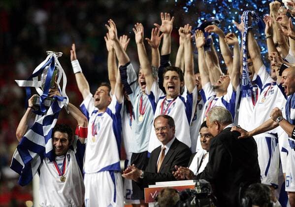 Kapitän Theodoros Zagorakis (li., Griechenland) präsentiert stolz den EM-Pokal, seine Teamkollegen jubeln hinter dem Rücken von UEFA-Präsident Lennart Johansson (vorn re., Schweden) und Eusebio (Mitte, Portugal) Fußball EM Herren Europameisterschaft, Euro 2004, Länderspiel, Nationalmannschaft, Nationalteam, Finale, Endspiel Totale Lissabon Glück, Begeisterung, Freude,