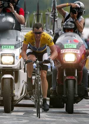 Lance Armstrong (USA US Postal Service) - hinter ihm scharen sich die Motorräder mit Fotografen und Kameramännern Radsport Herren Tour de France 2004, Straßenradsport, Straße, Rad, Zeitfahren, Einzelzeitfahren, Bergzeitfahren, Gruppe Dhuez 16. Etappe Bourg d Oisans - L Alpe d Huez Anstrengung,