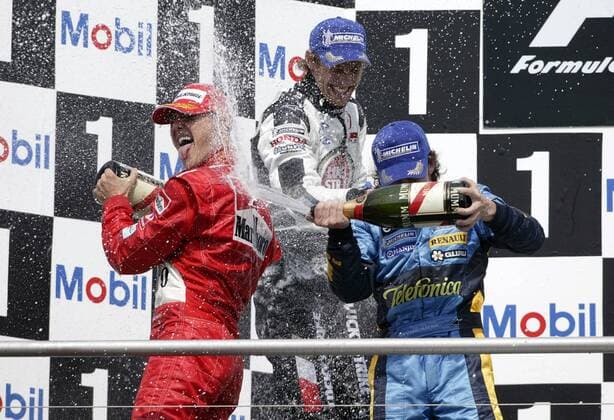 Siegerehrung beim GP von Deutschland 2004, v.li.: Michael Schumacher (Deutschland Ferrari), Jenson Button (England BAR-Honda) und Fernando Alonso (Spanien Renault) feiern mit einer Sektdusche Motorsport Grand Prix Herren Großer Preis von Deutschland 2004, Formel 1 Weltmeisterschaft, F1, F, GP, WM Gruppe Hockenheimring Hockenheim Freude, Begeisterung,