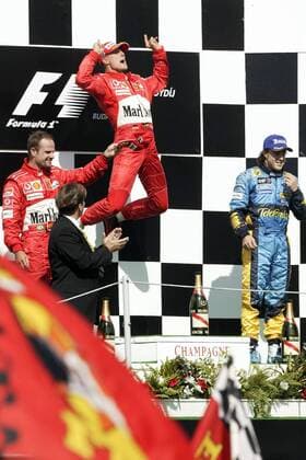 Siegerehrung beim GP von Ungarn 2004.: Sieger Michael Schumacher (Deutschland, Mitte) hüpft auf den freien Platz zwischen Rubens Barrichello (li., Brasilien beide Ferrari) und Fernando Alonso (Spanien Renault) Motorsport Grand Prix Herren Großer Preis von Ungarn 2004, Formel 1 Weltmeisterschaft, F1, F, GP, WM Gruppe Budapest Glück, Freude, Begeisterung,