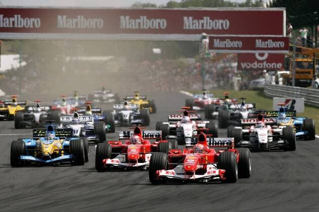 Start zum GP von Ungarn 2004.: Michael Schumacher (Deutschland Ferrari, vorne re.) führt das Starterfeld durch die erste Kurve Motorsport Grand Prix Herren Großer Preis von Ungarn 2004, Formel 1 Weltmeisterschaft, F1, F, GP, WM Totale Budapest