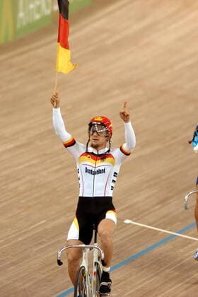 Olympiasieger Rene Wolff (Deutschland) dreht mit einer Nationalfahne eine Ehrenrunde Radsport OS Sommer Herren Olympische Sommerspiele Athen 2004, Olympia, Olympiade, Spiele, Rad, Bahn, Bahnrad, Bahnradsport, Einzelbild Maroussi Freude,
