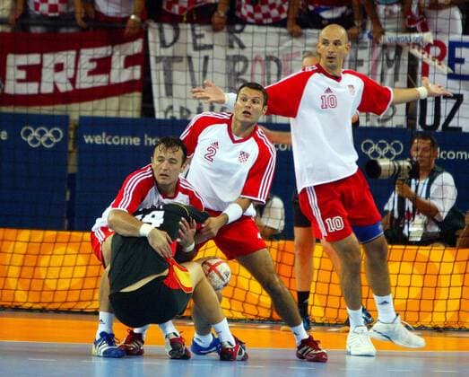 Christian Zeitz (Deutschland) wird von Slavko Goluza abgefangen, Niksa Kaleb und Davor Dominikovic (v.li., alle Kroatien) schauen zu Handball OS Sommer Herren Olympische Sommerspiele Athen 2004, Olympia, Olympiade, Spiele, Länderspiel, Finale, Endspiel Gruppe Helliniko Dynamik, Kampf,
