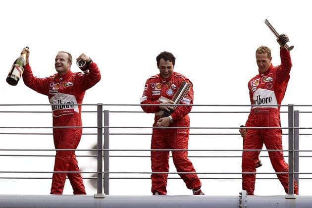 Siegerehrung nach dem GP von Italien in Monza 2004, v.li.: Sieger Rubens Barrichello (Brasilien), sein Renningenieur Gabriele Delli Colli (Italien) und Michael Schumacher (Deutschland alle Ferrari) jubeln Motorsport Grand Prix Herren Großer Preis von Italien 2004, Formel 1 Weltmeisterschaft, F1, F, GP, WM Gruppe Autodromo Nazionale Monza Begeisterung, Freude,