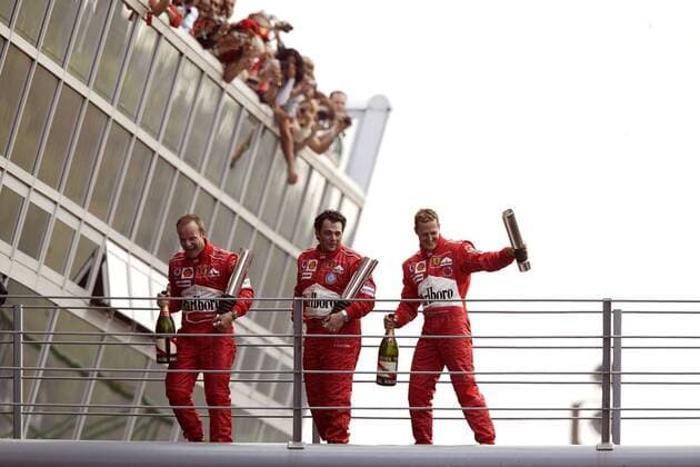 Siegerehrung nach dem GP von Italien in Monza 2004, v.li.: Sieger Rubens Barrichello (Brasilien), sein Renningenieur Gabriele Delli Colli (Italien) und Michael Schumacher (Deutschland alle Ferrari) jubeln Motorsport Grand Prix Herren Großer Preis von Italien 2004, Formel 1 Weltmeisterschaft, F1, F, GP, WM Gruppe Autodromo Nazionale Monza Begeisterung, Freude,