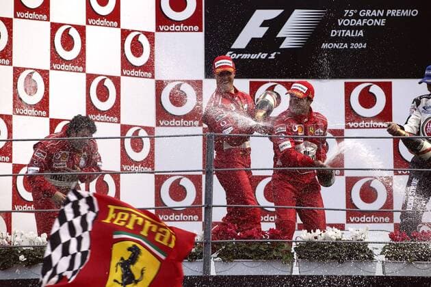 Siegerehrung nach dem GP von Italien in Monza 2004: Michael Schumacher (Deutschland, Mitte) und Sieger Rubens Barrichello (Brasilien, re.) verpassen Renningenieur Gabriele Delli Colli (Italien alle Ferrari, li.) eine Sektdusche Motorsport Grand Prix Herren Großer Preis von Italien 2004, Formel 1 Weltmeisterschaft, F1, F, GP, WM Gruppe Autodromo Nazionale Monza Begeisterung, Freude,
