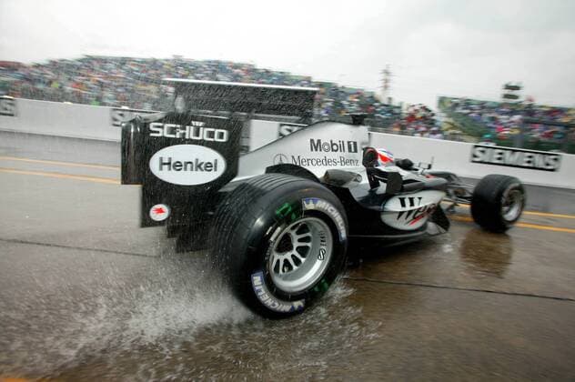 Kimi Räikkönen (Finnland McLaren-Mercedes) fährt mit seinem Boliden auf regennasser Fahrbahn in die Boxengasse Motorsport Grand Prix Herren Großer Preis von Japan 2004, Formel 1 Weltmeisterschaft, F1, F, GP, WM Einzelbild International Racing Course Suzuka
