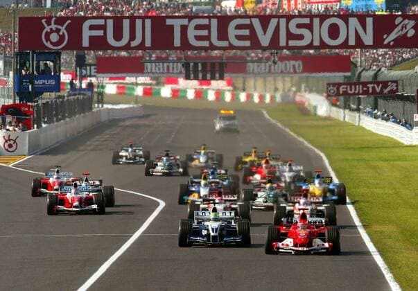 Start zum GP von Japan in Suzuka 2004: Michael Schumacher (Deutschland Ferrari, re.) führt das Feld vor seinem Bruder Ralf Schumacher (Deutschland BMW-Williams) an Motorsport Grand Prix Herren Großer Preis von Japan 2004, Formel 1 Weltmeisterschaft, F1, F, GP, WM Totale International Racing Course Suzuka Dynamik,