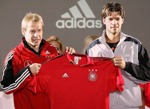 Bundestrainer Jürgen Klinsmann (li.) und Michael Ballack (beide Deutschland) stellen gemeinsam die neuen Trikots der Nationalmannschaft von adidas vor - rot wurde gewählt um Aggressivität auszustrahlen Fußball Herren Nationalmannschaft 2004, Nationalteam, Vorstellung, Präsentation, Pressetermin, Vdig Gruppe Leipzig, Auswärtstrikot
