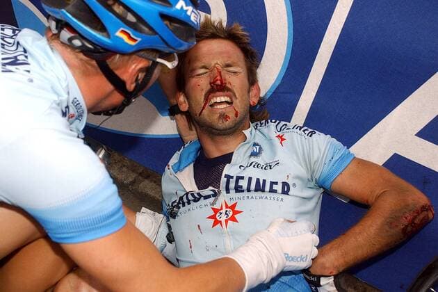 Rene Haselbacher (Österreich) liegt schwer verletzt und blutüberströmt am Boden und erhält Hilfe von seinem Teamkollegen Fabian Wegmann (Deutschland beide Gerolsteiner) Radsport Herren Tour de France 2004, Straßenradsport, Straße, Rad Gruppe 6. Etappe: Bonneval - Angers