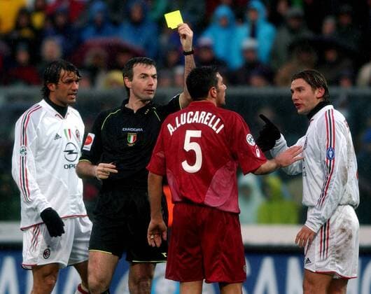 Alessandro Lucarelli (Livorno, 2.v.re.) bekommt während er mit Andriy Shevchenko (Milan, re.) diskutiert, die Gelbe Karte von Schiedsrichter Stefano Farina gezeigt, Paolo Maldini (Milan, li.) schaut zu Fußball Herren Serie A 2004 2005, 1. Italienische Liga, AS Livorno -AC Mailand 1:0 Gruppe Livorno