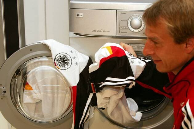 Hier wäscht der Chef noch selbst! - Bundestrainer Jürgen Klinsmann (Deutschland) holt als Marken-Botschafter für LG Electronics ein Nationaltrikot aus der Waschmaschine des südkoreanischen Elektrokonzerns Fußball Herren Nationalmannschaft 2005, Nationalteam, Pressekonferenz, PK, Pressetermin, Einzelbild Düsseldorf