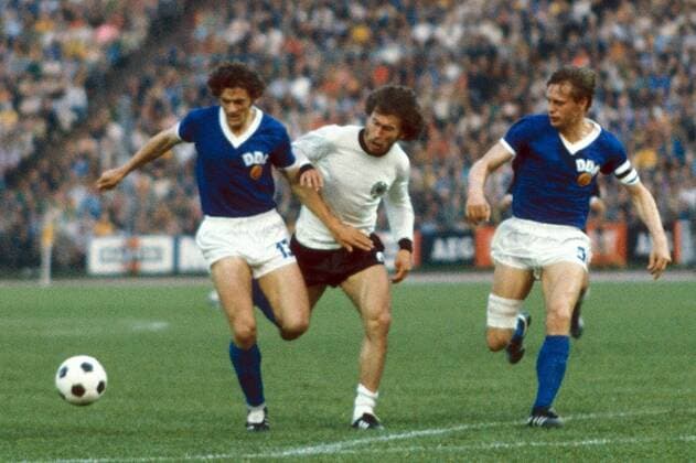 Paul Breitner (Mitte, BR Deutschland) gegen Reinhard Lauck (li.) und Bernd Bransch (beide DDR) Fußball WM Herren DEUTSCHSPRACHIGE SPORTZEITSCHRIFTEN UND -ZEITUNGEN NUR NACH RÜCKSPRACHE, Weltmeisterschaft 1974 Gruppe Hamburg Dynamik,