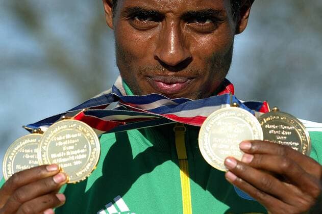 Doppelweltmeister Kenenisa Bekele (Äthiopien) zeigt stolz seine vier Goldmedaillen Leichtathletik WM Herren Cross Country Weltmeisterschaft 2005, Lauf, Crosslauf, Crosscountry, Einzelbild pan8674, Querfeldein, Aufmacher Saint Etienne Saint Galmier, St.  
