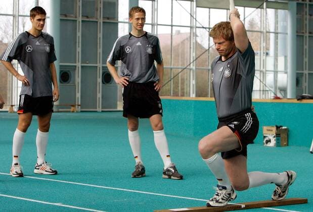 Torwart Oliver Kahn (vorn) testet auf einem Holzbalken seine Balance, Sebastian Kehl (li.) und Frank Fahrenhorst (alle Deutschland) schauen interessiert zu Fußball Herren Nationalmannschaft 2005, Nationalteam, Training, Vorbereitung, Vdig Gruppe Fitneß, Fitness, Fitneßtraining, Fitnesstraining Frankfurt M., Leistungstest