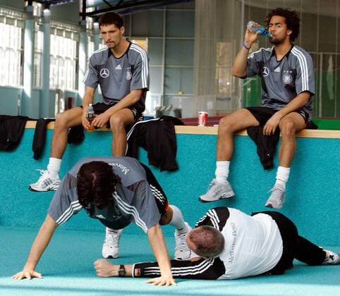 Michael Ballack (li., Deutschland) macht unter Anleitung von Trainingsberater Mark Verstegen (USA Athletes Performance) Liegestütze, Kevin Kuranyi (hi.li.) und Patrick Owomoyela (beide Deutschland) schauen skeptisch zu Fußball Herren Nationalmannschaft 2005, Nationalteam, Training, Vorbereitung, Trainingswissenschaft, Vdig Gruppe Fitneß, Fitness, Fitneßtraining, Fitnesstraining Frankfurt M., Fitneßcoach, Fitnesscoach