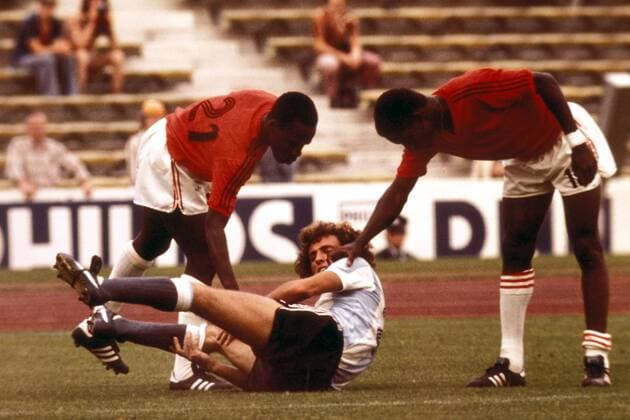 Enrique Wolff (Mitte, Argentinien) liegt verletzt am Boden, Wilfred Louis (li.) und Serge Racine (beide Haiti) entschuldigen sich artig Fußball WM Herren Weltmeisterschaft 1974, Nationalmannschaft, Nationalteam, Nationaltrikot, Länderspiel, Gruppe München