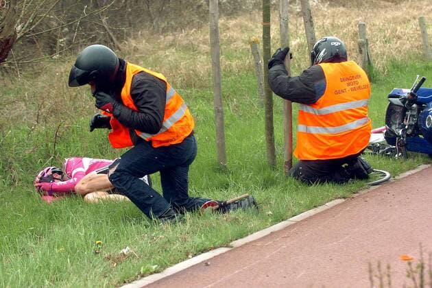 Andreas Klier (Deutschland T Mobile) liegt nach seinem Sturz zusammengekauert am Straßenrand, die Fahrer des Begleitmotorrades kümmern sich vorerst nur um sich selbst oder um einen Baumschutz -  Radsport Herren Gent - Wevelgem 2005, ProTour, Straßenradsport, Straße, Rad, Vdig Gruppe Graben
