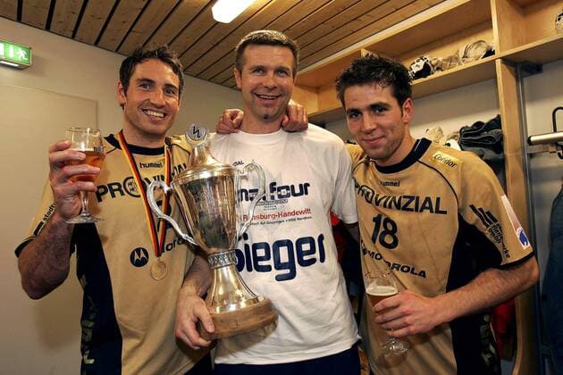 Co Trainer Bogdan Wenta (Mitte), Glenn Solberg (li.) und Torge Johannsen (alle Flensburg) präsentieren in der Umkleide stolz die Siegertrophäe des DHB Pokals Handball 1. BL Herren DHB Pokal 2004 2005, Pokalspiel, Final Four, 4, SG Flensburg Handewitt, Gruppe Umkleide, Umkleidekabine, Kabinenfeier, Hamburg Freude,