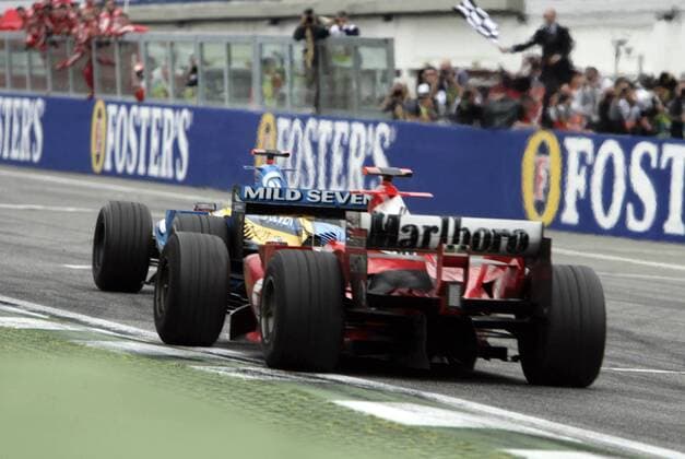 Sieger Fernando Alonso (Spanien Renault) fährt dicht gefolgt von Michael Schumacher (Deutschland Ferrari) mit seinem Boliden über die Ziellinie Motorsport Grand Prix Herren Großer Preis von San Marino 2005, Formel 1 Weltmeisterschaft, F1, F, GP, WM Gruppe Imola Spannung