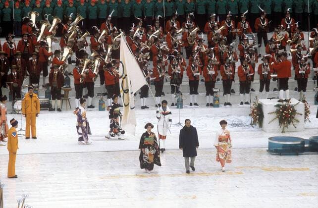 Takeshi Itagaki (Mitte, Japan), Bürgermeister von Sapporo, übergibt während der Eröffnungsfeier als Ausrichter der letzten Winterspiele die olympische Fahne an Innsbruck Alpiner Skilauf OS Winter Herren Olympische Winterspiele 1976, Olympia, Olympiade, Spiele, Ski Alpin, Nordischer Skisport, Vdia Totale Eröffnungsveranstaltung, Eröffnungsfeier Innsbruck