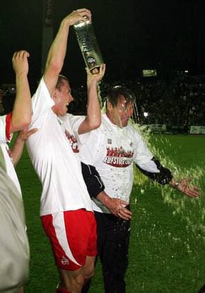 Trainer Huub Stevens bekommt für den Aufstieg eine Bierdusche von Lukas Podolski (beide Köln) verpasst Fußball 2. BL Herren Saison 2004 2005, 1. FC Köln Gruppe Aue Freude, Begeisterung,