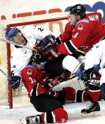 Toni Soderholm (Finnland, li.) wird von Kirk Maltby (re.) und Kris Draper (beide Kanada) vor dem Kasten abgefangen Eishockey WM Herren IIHF Weltmeisterschaft 2005, Länderspiel, Nationalmannschaft, Nationalteam, Nationaltrikot, Gruppe Innsbruck Dynamik, Kampf,