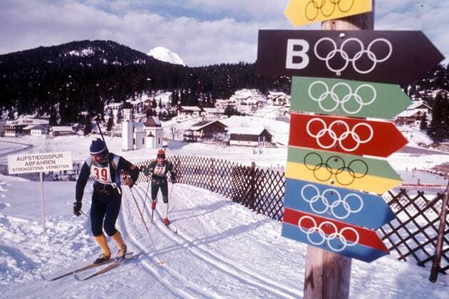 Karl Heinz Wolf (li., DDR) mißachtet den Olympischen Wegweiser und entfernt sich von der Loipe Biathlon OS Winter Herren Olympische Winterspiele Innsbruck 1976, Olympia, Olympiade, Spiele, Vdia Totale Seefeld