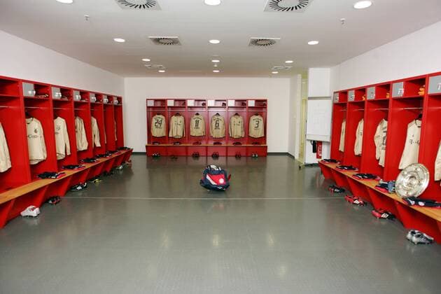 Fotostory: Die Kabine der Bayern in der Münchner Allianz Arena mit einer Nachbildung der Meisterschale, in jedem Spielerschrank hängt die Spielkleidung, darunter die dazugehörigen Fußballschuhe Fußball 1. BL Herren Saison 2004 2005, FC Bayern München, Stadion, Fußballstadion, innen, Innenansicht, Vdig Totale AllianzArena, Arena, Stadionstory, Reportage Deutscher Meister, Deutsche Meisterschaft, Allianz