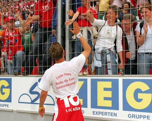 Lukas Podolski (Köln, li.) klatscht mit den Fans ab, mit einem Aufdruck auf dem Rücken seines Shirts bedankt er sich noch einmal schriftlich für die Unterstützung Fußball 2. BL Herren Saison 2004 2005, 1. FC Köln, Aufstiegsfeier, Aufstieg, Aufsteiger, Feier Gruppe Köln Freude,