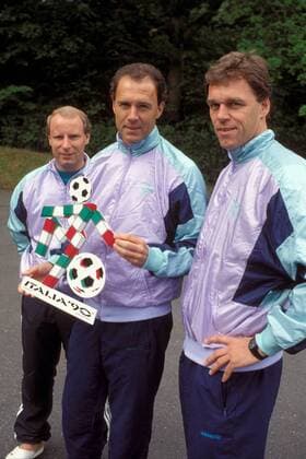 Teamchef Franz Beckenbauer (Mitte) und seine Assistenten Holger Osieck (re.) und Berti Vogts (alle BR Deutschland) mit dem WM Logo Italia 90 Fußball WM Herren DEUTSCHSPRACHIGE SPORTZEITSCHRIFTEN UND -ZEITUNGEN NUR NACH RÜCKSPRACHE, Vorschau 1990, Vdia Gruppe