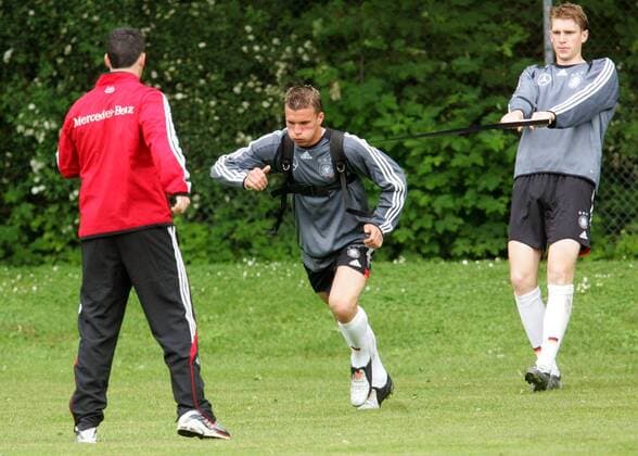 Schnellkrafttraining: Per Mertesacker (re.) hält Lukas Podolski (Mitte, beide Deutschland) am Gummiband Fußball Herren Nationalmannschaft 2005, Nationalteam, Training, Vorbereitung, Vdig Gruppe Gummibänder Dynamik, Kraft,