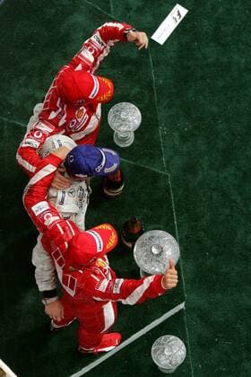 Siegerehrung Großer Preis von Kanada 2005 - Kimi Räikkönen (Finnland McLaren Mercedes) bejubelt im Ferrari-Sandwich mit Michael Schumacher (Deutschland, 2.) und Rubens Barrichello (Brasilien, 3.) seinen Sieg Motorsport Grand Prix Herren Großer Preis von Kanada 2005, Formel 1 Weltmeisterschaft, F1, F, GP, WM, Vdig, Gruppe Montreal Freude,