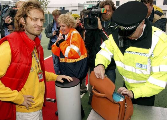 Jarno Trulli (Italien Toyota) muss seine Tasche von einem englischen Polizisten genaustens untersuchen lassen - die Terroranschläge vom 7. Juli 2005 in London haben zu einer Verschärfung der Sicherheitsvorkehrungen rund ... Motorsport Grand Prix Herren Großer Preis von England 2005, Formel 1 Weltmeisterschaft, F1, F, GP, WM, TV, Fernsehen, Kamera Gruppe kontrollieren, Sicherheitskräfte, Aktentasche Silverstone o0 Gesellschaft