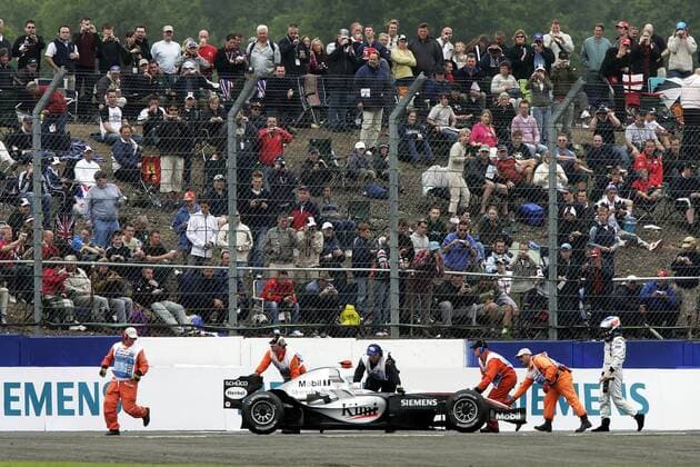 Kimi Räikkönen (Finnland McLaren Mercedes) verfolgt den Abtransport seines defekten Boliden Motorsport Grand Prix Herren Großer Preis von England 2005, Formel 1 Weltmeisterschaft, F1, F, GP, WM, Qualifying, Vdig, Totale Silverstone