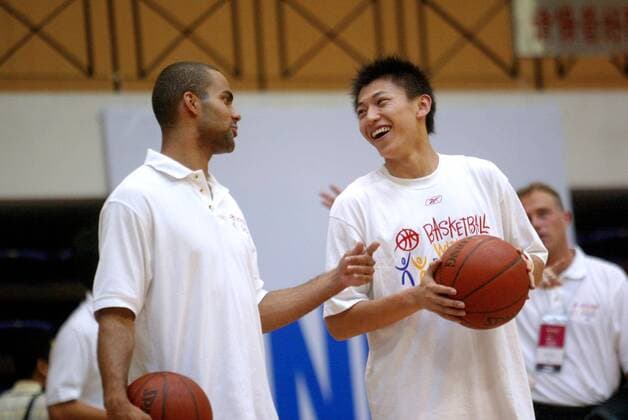 Tony Parker (Frankreich San Antonio Spurs, li.) unterhält sich während des NBA Trainingscamps Basketball Without Borders mit einem Campteilnehmer -  Basketball Herren Basketball Without Borders 2005, Trainingscamp, Basketballcamp Gruppe IMC20050717a04 Beijing