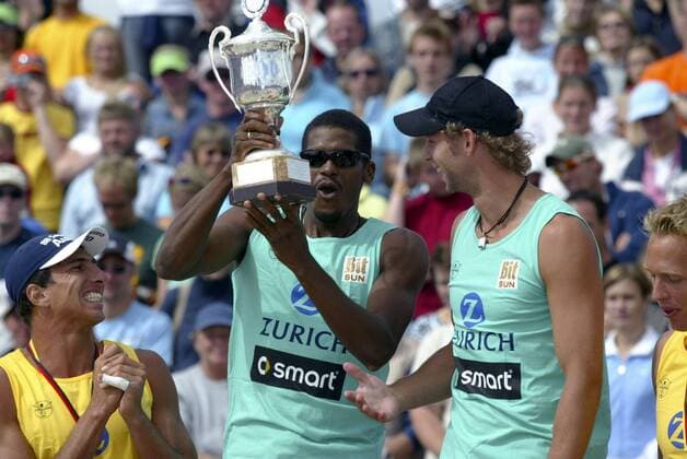Siegerehrung Zürich Masters 2005 in St. Peter Ording: Die Sieger Gil Ferrer Cutino (Kuba, 2.v.li.) und Thomas Kröger (Deutschland, re.) jubeln mit ihrer Trophäe, auf die Jan Ferreira (Brasilien) augenscheinlich auch Lust hätte Beachvolleyball Herren Zürich Masters 2005, Zurich, Zuerich, Beach Gruppe St. Peter Ording Begeisterung, Freude,