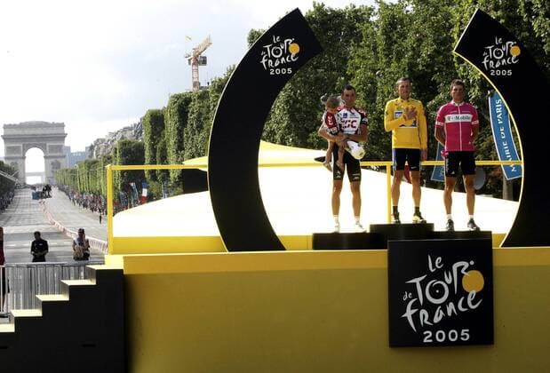 Siegerehrung Tour de France 2005 auf dem Champs Elysees - Gesamtsieger Lance Armstrong (USA Discovery Channel, Mitte) zwischen Jan Ullrich (Deutschland T Mobile, re.) und Ivan Basso (Italien CSC) mit Tochter Domitilla Radsport Herren Tour de France 2005, ProTour, Straßenradsport, Straße, Rad Gruppe pan10246 Sehenswürdigkeit, Wahrzeichen Paris  