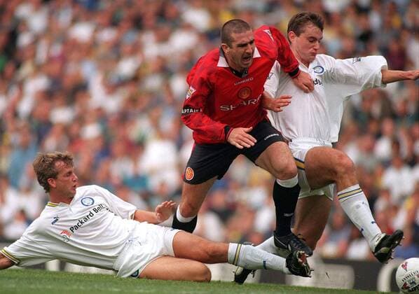 Eric Cantona (Mitte, Manchester United) gegen Richard Jobson (li.) und David Wetherall (beide Leeds) -  Fußball Herren English Premier League 1996 1997, Leeds United - Manchester United 0:4, ManU, Vneg Gruppe Leeds Dynamik, Kampf,