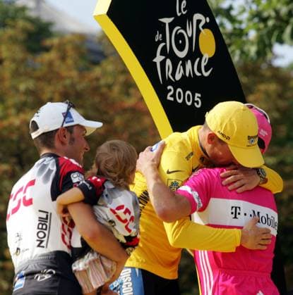 Jan Ullrich (Deutschland T Mobile, re.) umarmt Tour Sieger Lance Armstrong (USA Discovery Channel, Mitte), daneben Ivan Basso (Italien CSC) mit Tochter Domitilla Radsport Herren Tour de France 2005, ProTour, Straßenradsport, Straße, Rad, Gesamtsieg Gruppe Toursieg, Toursieger Paris Champs Elysees Elysee Kameradschaft