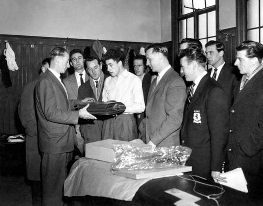 Stanley Matthews (Blackpool, li.) bekommt vom Team von Aston Villa zu seinem 43. Geburtstag eine Aktentasche geschenkt, in der Kabine darf sie ihm der 16jährige Walter Hazelden (Aston Villa, 4.v.li.) überreichen -  Fußball Herren English First Division 1957 1958, 1. Englische Liga, Aston Villa - FC Blackpool 1:1 Totale Birmingham Harmonie,