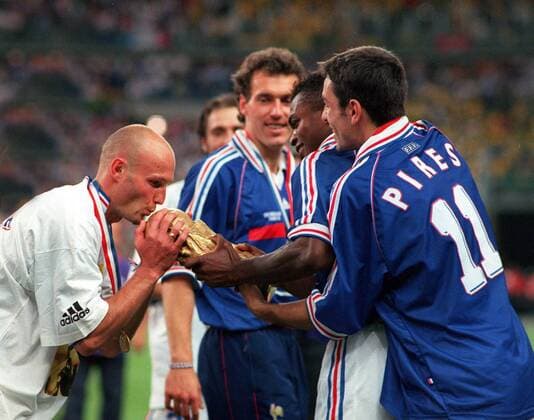 Weltmeister Frankreich - Frank Leboeuf (li.) küsst den Weltpokal, daneben Robert Pires (re.), Marcel Desailly (2.v.re.) und Laurent Blanc - Fußball WM Herren Weltmeisterschaft 1998, Nationalmannschaft, Nationalteam, Nationaltrikot, Länderspiel, Finale, Gruppe FIFA World Cup, WorldCup, Paris St. Denis, Endspiel Glück, Begeisterung, Freude,