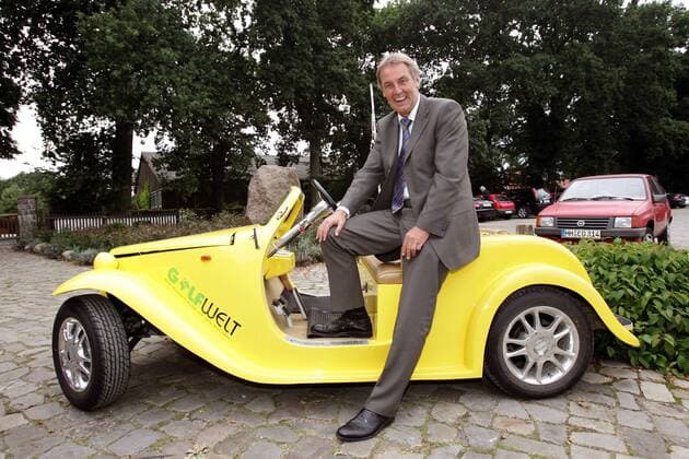 RBU Charity Golfturnier: Sat.1 Moderator Jörg Wontorra (Deutschland) posiert auf dem California Roadster des Magazins Golfwelt Golf Herren RBU Charity Golfturnier von Franz Beckenbauers Stiftung 2005, Golf, Fußball, Wohltätigkeit, Benefiz Einzelbild St. Leon Rot Freude,