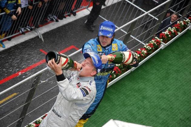 Siegerehrung Großer Preis von Belgien 2005 - Sieger Kimi Räikkönen (Finnland McLaren Mercedes, li.) gönnt sich einen Schluck Sekt, Fernando Alonso (Spanien Renault) verpasst ihm die obligatorische Sektdusche Motorsport Grand Prix Herren Großer Preis von Belgien 2005, Formel 1 Weltmeisterschaft, F1, F, GP, WM, Gruppe Spa-Francorchamps Freude, Begeisterung,