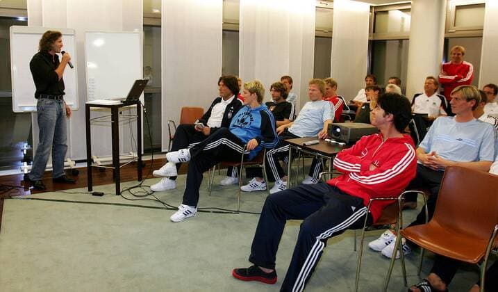 Extremkletterer Stefan Glowacz (li.) referiert vor der deutschen Fußballnationalmannschaft über Erfahrungen im persönlichen Grenzbereichen, vorn v.li.: Mannschaftsarzt Müller Wohlfahrt, Schweinsteiger, Co Trainer Löw und Borowski (alle Deutschland) Fußball Herren Nationalmannschaft 2005, Nationalteam, Vorbereitung, Motivation, motivieren, Psychologie, Vdig Totale Hamburg